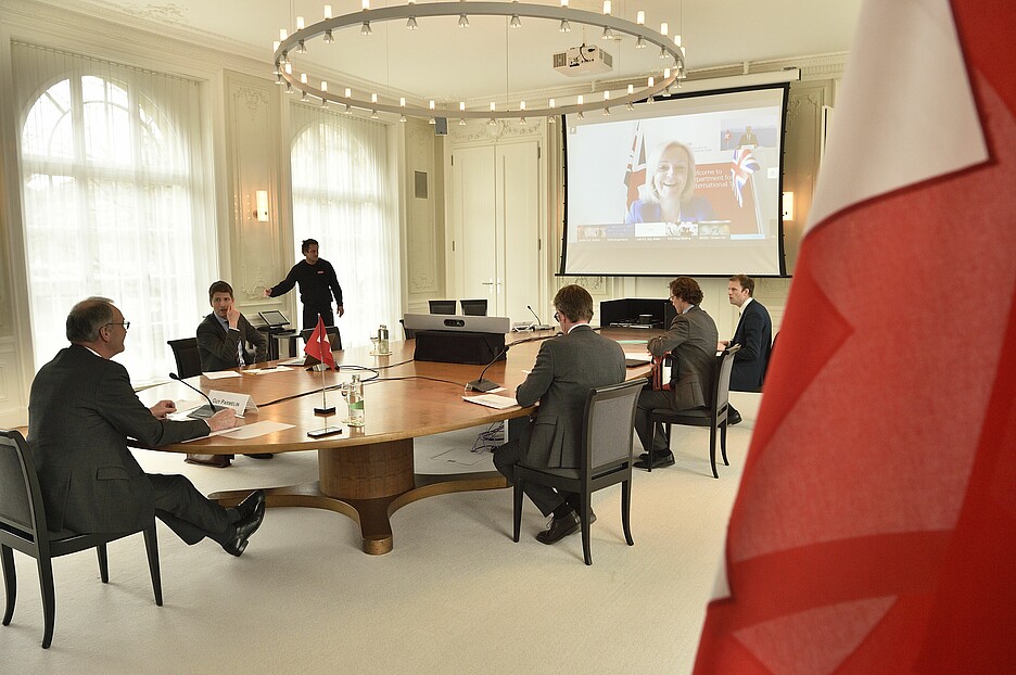 Extraordinary video conference of the G20 ministers of trade on the corona crisis in March 2020: Federal councillor Guy Parmelin and employees in Bern. On the screen, Elizabeth Truss, then trade secretary and currently prime minister of the United Kingdom. / Photo: KEYSTONE / Markus A. Jegerlehner